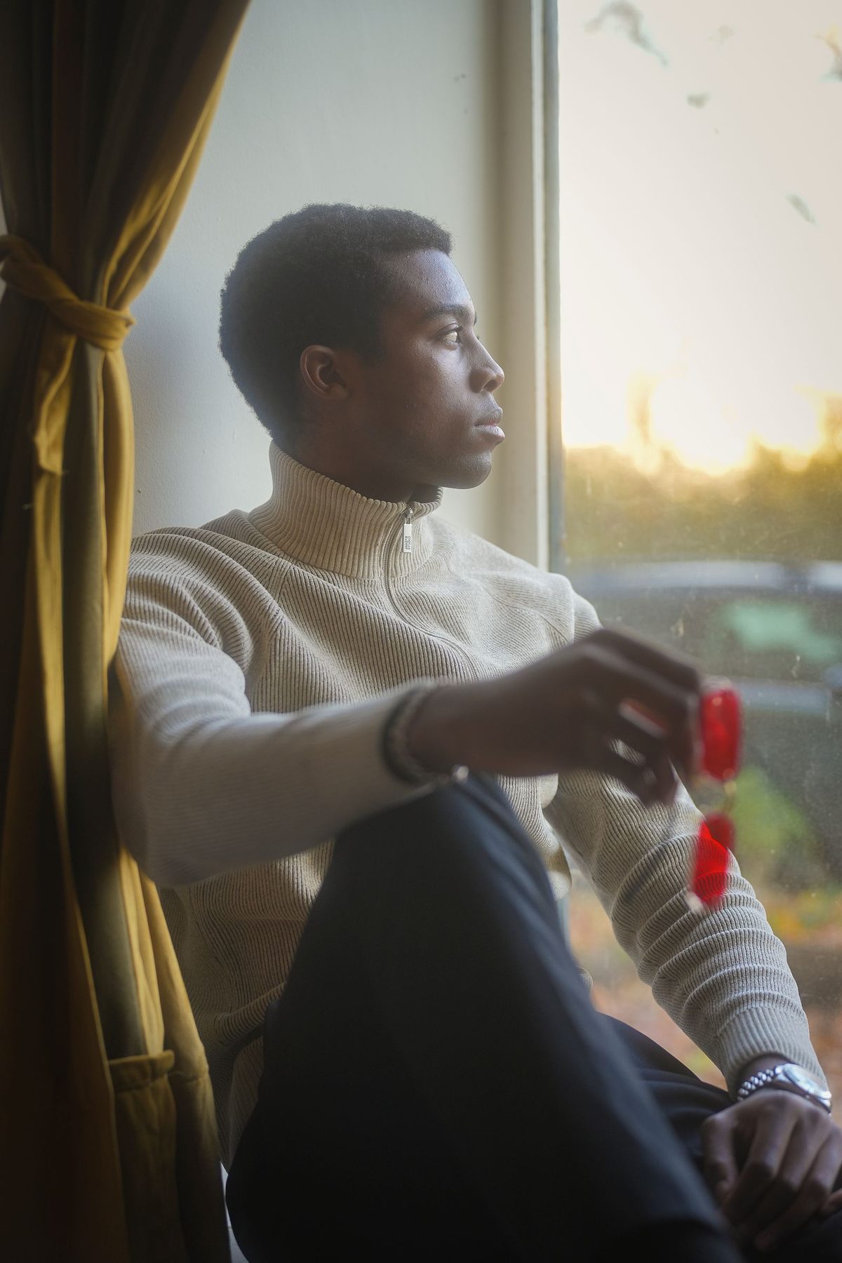 A man sitting quietly by a window in warm light, calm and reflective, noticing what is happening inside