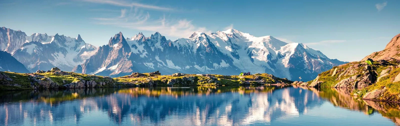 The Mont Blanc massif reflected in a still alpine lake, seen from the Lac Blanc side above Chamonix, with the Aiguilles on the left and the snow dome of Mont Blanc on the right